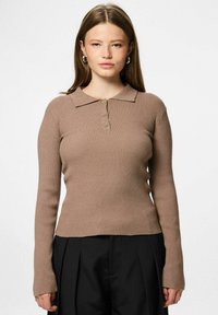 Top marrón de manga larga y acanalado con cuello y tres botones en la parte frontal. Presenta un ajuste ceñido y una tela texturizada. Combinado con pantalones negros.