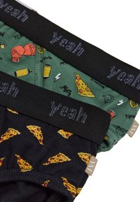 Dos pares de bóxer para hombre con un diseño negro con pequeños estampados de pizza y un diseño verde con ilustraciones relacionadas con la comida, marcados "Sí."