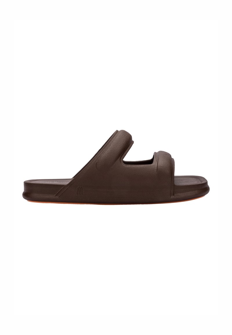 Brun sandal med slät yta och två utskärningar, med en bred remdesign och en något upphöjd sula.