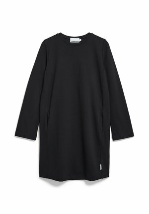 Zwarte jurk tot op de knie met lange mouwen, gemaakt van rekbare stof. Voorzien van zijzakken en een ronde halslijn. Eenvoudig, minimalistisch ontwerp.