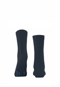 Une paire de chaussettes de lavage unies bleu marine avec des bords côtelés, l'une montrant la semelle avec un texte de marque bleu clair et des indications de taille.