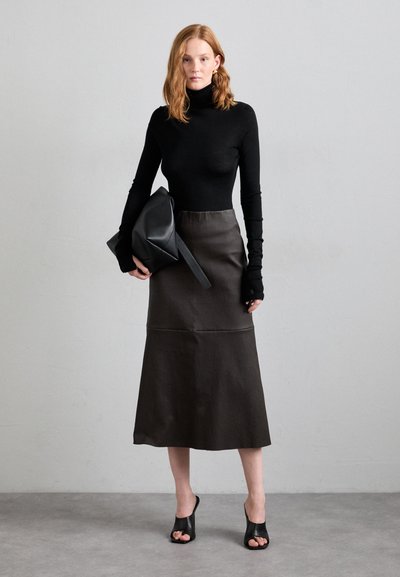 Black fitted turtleneck top, dark brown flared skirt, and black open-toe heels. Accessories include a black structured bag. Smooth textures.