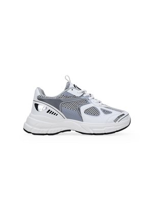 Zapatilla deportiva blanca y gris con paneles de malla, acentos texturizados y una suela de goma gruesa con detalles en negro.