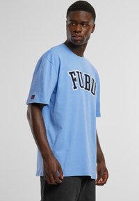 Tricou din bumbac de culoare albastră, cu un logo negru îndrăzneț "FUBU" pe piept, cu mâneci scurte și un design lejer.