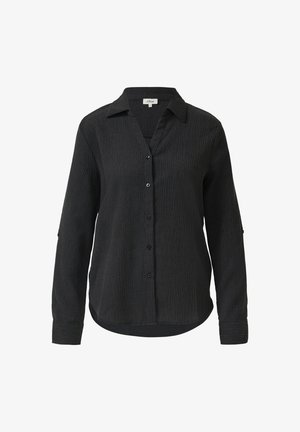 Chemise noire à manches longues avec un tissu texturé, fermeture boutonnée à l'avant et col. Comprend un ourlet courbé et des manches retroussées avec des détails à boutons.