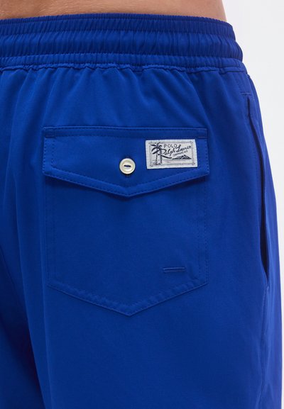 Μπλε μαγιό σορτς από ελαφρύ ύφασμα, με ελαστική μέση, πίσω τσέπη με κούμπωμα snap και επώνυμη ετικέτα.