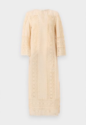Světlý béžový šaty s jemným krajkovým zdobením podél rukávů a boků, s volným střihem a decentním výstřihem do V.
