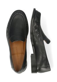 Czarne skórzane mokasyny o gładkiej fakturze, zaokrąglonym nosku i subtelnych detalach przeszyć, z niskim, warstwowym obcasem oraz beżową wkładką.