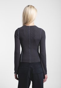 Maglietta a maniche lunghe in tessuto a coste grigio scuro con cuciture a contrasto blu chiaro, caratterizzata da un design aderente e collo rotondo.