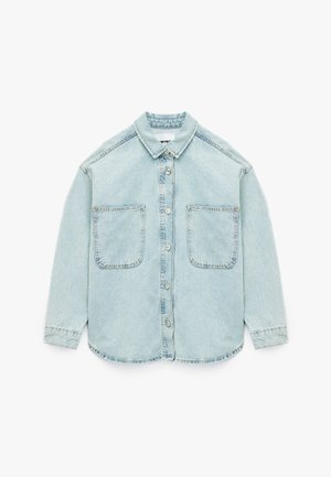 Camicia in denim azzurro chiaro con chiusura a bottoni, due grandi tasche sul petto, colletto e maniche lunghe con polsini; texture morbida e vestibilità comoda.