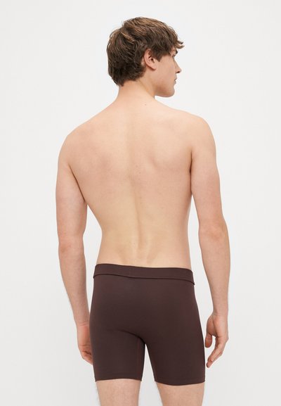 Καφέ μποξεράκια με άνετη εφαρμογή, που διαθέτουν μαλακή μέση και λεία υφή. Η εικόνα δείχνει την πλάτη, τονίζοντας το σχέδιο.