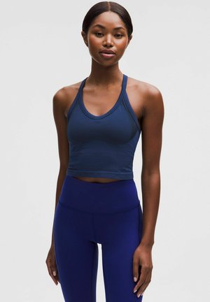 Granatowy sportowy crop top z okrągłym dekoltem, grubymi ramiączkami i teksturowanym materiałem, w zestawieniu z wysokimi, jednolitymi granatowymi legginsami.