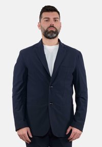 Blazer blu navy con due bottoni, rever a punta e taschino sul petto. Realizzato in tessuto liscio con una vestibilità su misura, presenta dettagli sul seam anteriore.