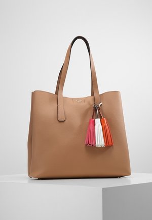 Brązowa skórzana torba typu tote z dwoma uchwytami i trzema brelokami w kolorach różowym, białym i pomarańczowym zawieszonymi na jednym z uchwytów.