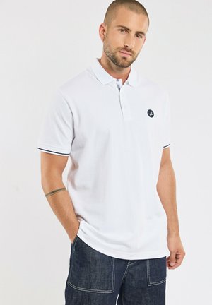 Weißes Poloshirt mit Kragen, mit kontrastierenden schwarzen Säumen an den Ärmeln und einem kleinen Logo auf der Brust. Aus weichem Baumwollmaterial.