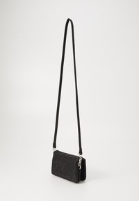 Borsa nera con superficie testurizzata, con strass, una cintura regolabile e chiusura con zip. Design compatto e piatto.