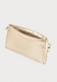 Borsa a busta rettangolare metallica dorata con zip nella parte superiore e piccola tracolla rimovibile su sfondo bianco.
