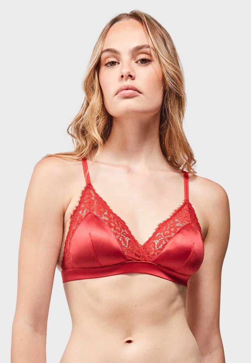 Bralette de satén rojo con un borde de encaje en el escote y las tirantes, con una textura suave y copas triangulares.