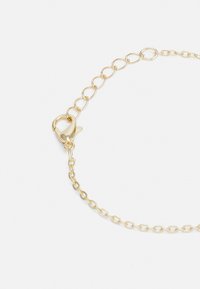 Pulseira de corrente em metal dourado com fecho de lagosta, apresentando elos ovais e uma textura lisa. Design simples e elegante.
