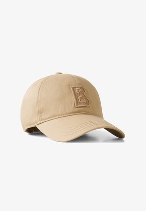 Beige baseballkasket med buet skygge og hævet, syet bogstav "B" på frontpanelet, sat mod en hvid baggrund.