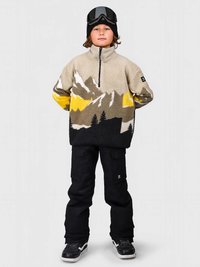 Πουλόβερ τζάκετ σε μπεζ φλις με γραφικό βουνού σε γκρι, κίτρινο και μαύρο. Μαύρα παντελόνια σκι. Μαύρα γυαλιά και σκουφί.