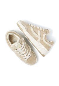 Beige Wildledersneaker mit weichen, flauschigen Akzenten, ausgestattet mit weißen Schnürsenkeln und einer strukturierten Gummisohle. Klassisches Low-Top-Design mit minimalen Details.