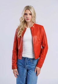 Röd läderjacka i bomberstil med mandarin-krage och dragkedjestängning, tillsammans med en vit topp och blå jeans.