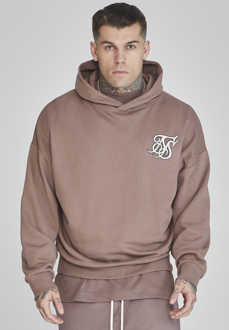 Sudadera marrón hecha de una tela suave y ligera. Cuenta con un bolsillo delantero, puños acanalados y un logo bordado en el lado izquierdo del pecho.