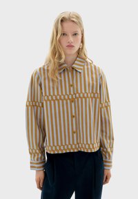 Striped button-down skjorte med krave, med skiftende sennepsgul og lyseblå striber, lavet af et tekstureret stof.