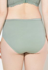 Hoge taille mintgroene onderbroek van gladde stof met een contrasterende grijze elastische tailleband en nette stikdetails.