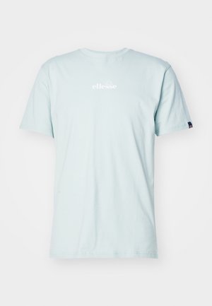 Camiseta de algodón azul clara con mangas cortas y cuello redondo. Presenta un logo blanco de "ellesse" en el pecho y una pequeña etiqueta decorativa en la manga.
