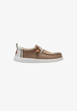 Light brown casual slip-on shoe with white sole, white heel tab, lace detail, and stitched accents, shown from the side on white background.