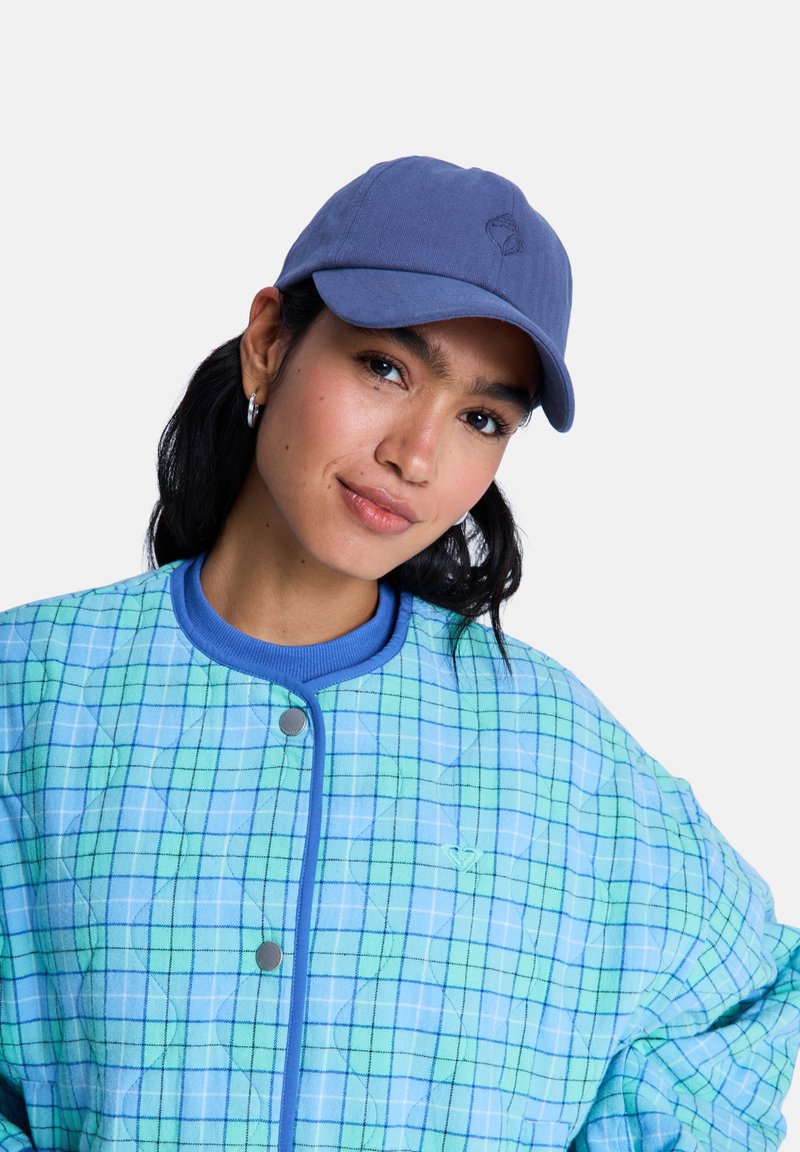 Chaqueta acolchada con un estampado de cuadros azul y verde, que cuenta con un cuello acanalado y botones a presión. Tejido suave y texturizado. Gorra de béisbol azul incluida.