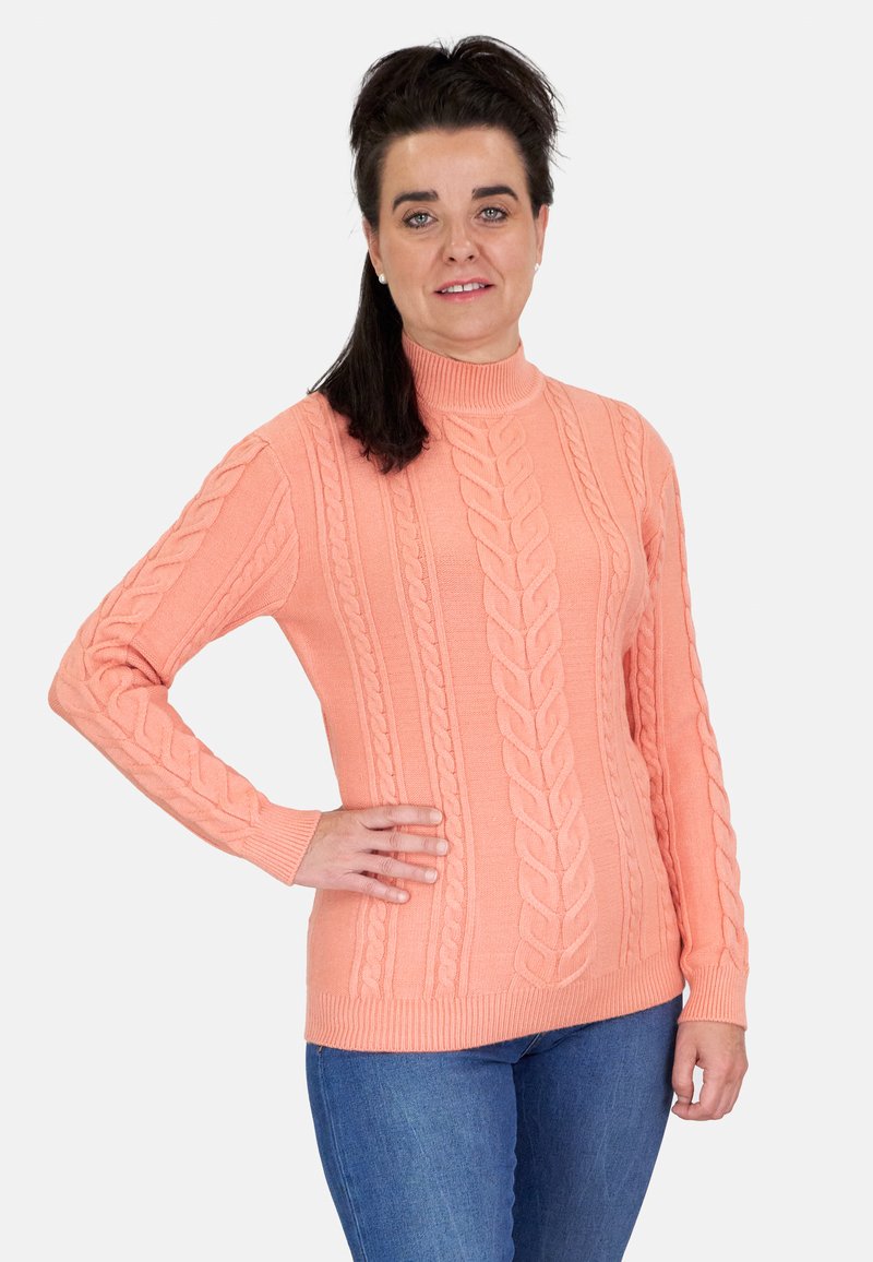 Suéter de cuello alto de coral de punto con patrones de trenzas, mangas largas, puños y dobladillo acanalados, combinado con jeans azules.