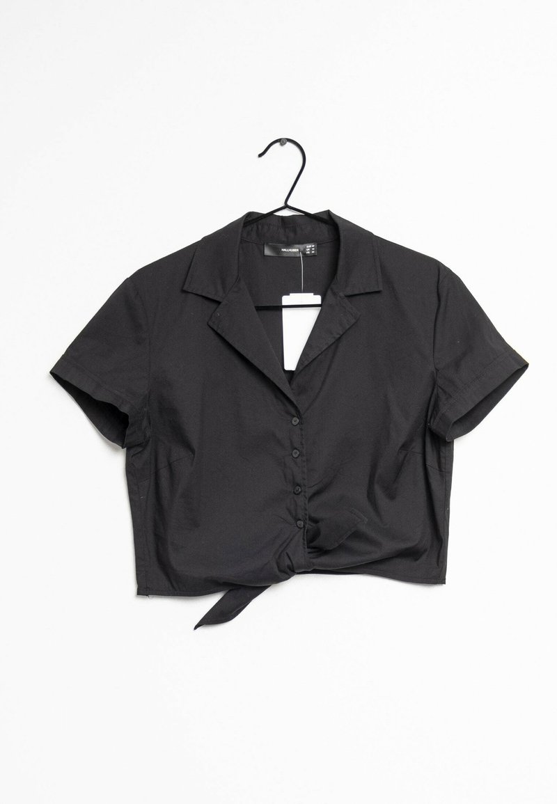 Blusa nera cropped con colletto, maniche corte, chiusura frontale con bottoni e dettaglio annodato all'orlo. Realizzata in tessuto liscio, presenta un design minimalista.