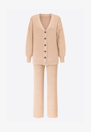 Beige gestrickte Strickjacke mit V-Ausschnitt, langen Ärmeln und fünf Knöpfen. Kombiniert mit passenden, gerippten Hosen mit weitem Bein, beide aus strukturiertem Stoff.
