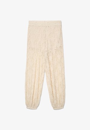 Pantaloni in pizzo color crema con vita e polsini elasticizzati, con motivi floreali su tutto il tessuto.