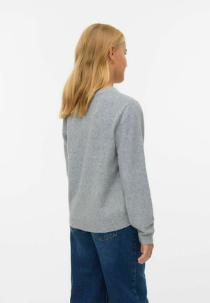 Jersey gris de punto con cuello redondo y mangas largas, con un dobladillo acanalado. Llevado con jeans de mezclilla azules, visto desde atrás.