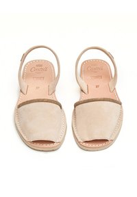 Sandalias de ante beige con puntera abierta y correas traseras, que presentan un detalle decorativo en tono dorado y costuras blancas sobre una suela marrón clara. Talla 37.