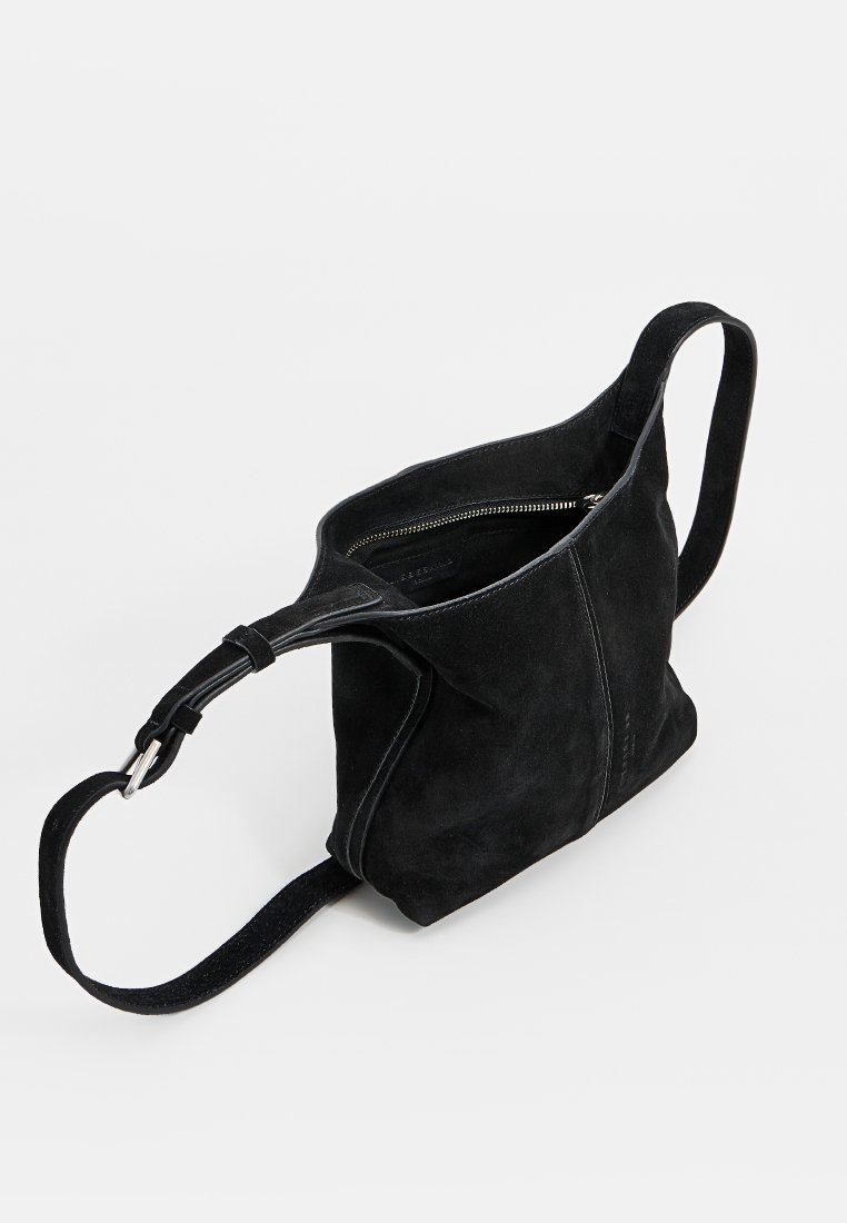 Bolso de hombro de ante negro con textura suave, cierre con cremallera y una sola correa ajustable. Presenta detalles de costura sutiles.