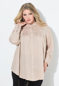Camicia button-up beige con dettagli plissettati, maniche lunghe e colletto alla mandarino. Tessuto morbido con una vestibilità rilassata.