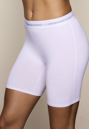 White seamless shorts with a smooth texture, featuring a matching waistband labeled "COPENHAGEN STUDIOS." Mid-thigh length with a snug fit.