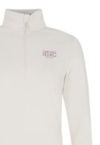 Witte ritssluiting pull met hoge kraag. Bevat de tekst "LATEN WE SKIËN PROTESTEREN" in veelkleurige letters op de linker borst. Zachte textuur.
