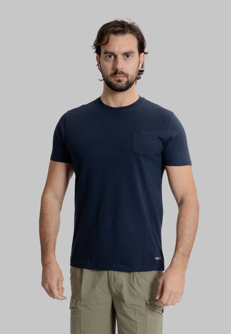 T-shirt in cotone blu navy con maniche corte, scollatura rotonda e taschino sul lato sinistro del petto. Presenta una texture morbida e un design aderente.
