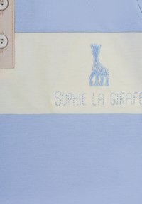 Tessuto a righe blu e crema con bottoni, dotato di ricamo "Sophie la girafe" e un logo di giraffa sul lato sinistro. Texture morbida.