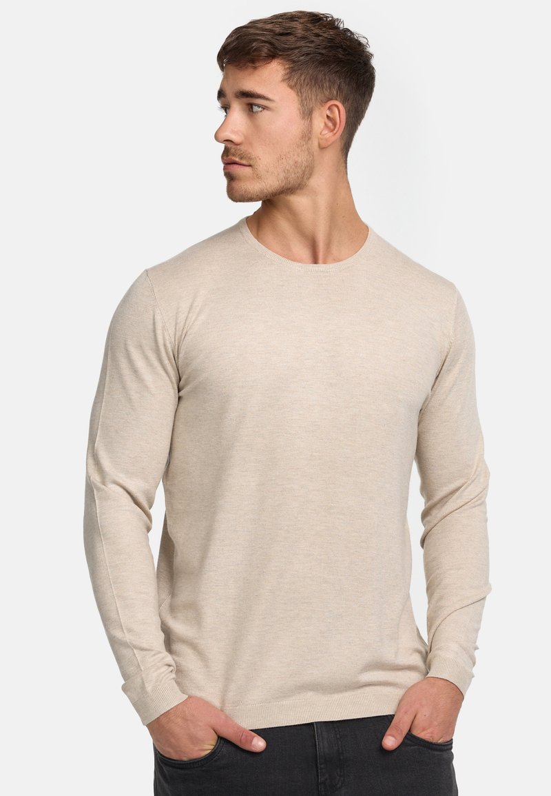 Chemise beige à manches longues avec un col rond, coupe slim, en tissu tricoté texturé, dotée de poignets et d'un ourlet côtelés.