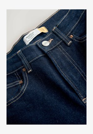 Bootcut džíny v tmavě modrém denimu, s mírným vzestupem pasu, zlatým šitím, kovovým knoflíkem a předními kapsami. Viditelná visačka.