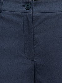 Close-up af mørkeblå stofbukser med knaplukning i taljen og skjult lynlåsgylp med synlige syninger.