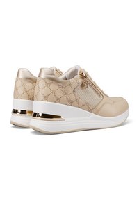Sneaker beige con un design a motivi, dettagli metallici e una suola bianca rialzata. Presenta una zip laterale e una sovrapposizione in tessuto testurizzato.