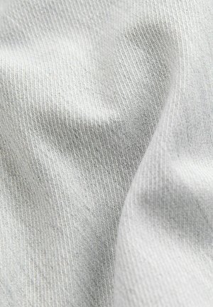 Tejido gris claro con una superficie suave y ligeramente texturizada, con un patrón de estrías sutil, que muestra pliegues y arrugas en su caída.